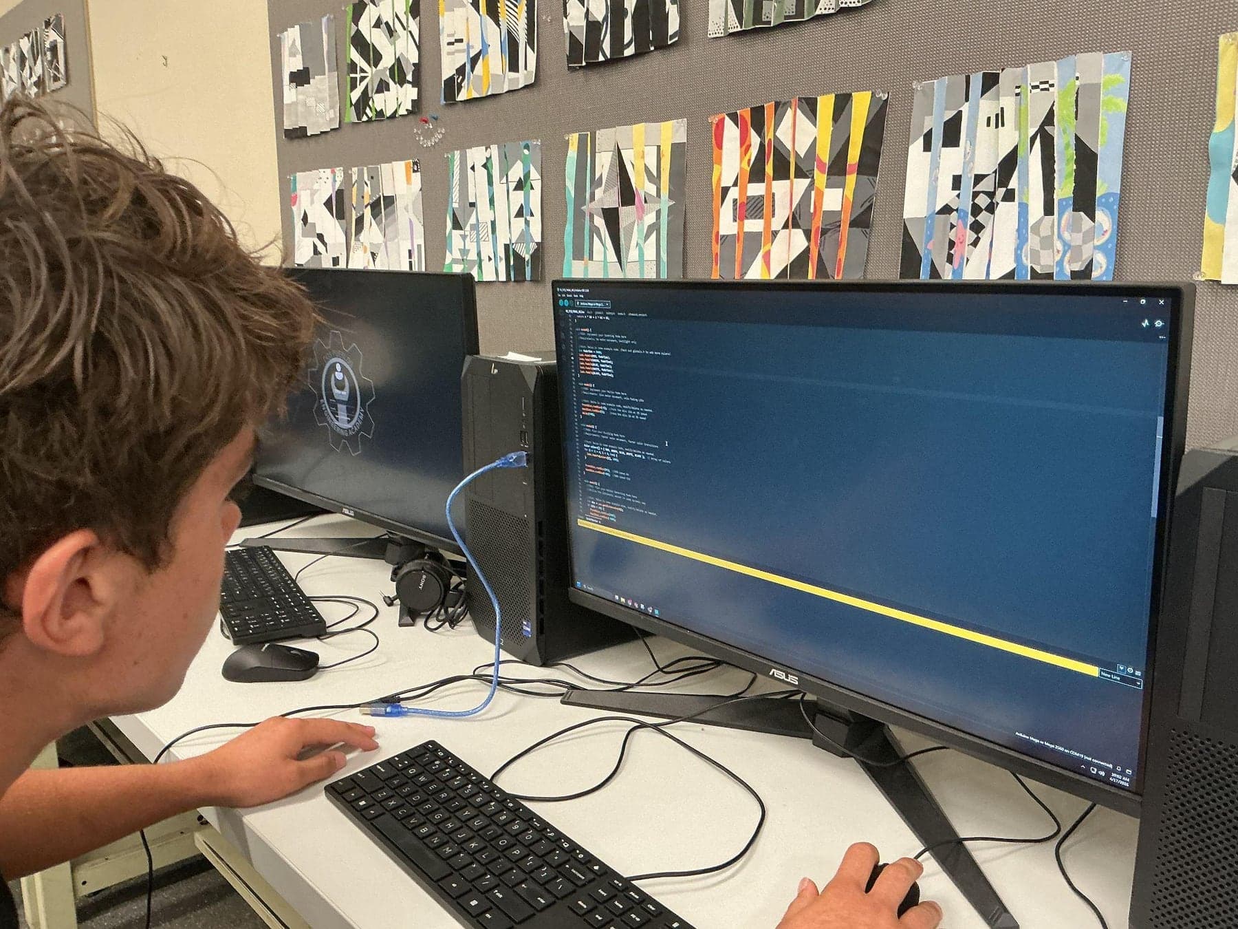 Writing and debugging the sculpture's code at a computer workstation.