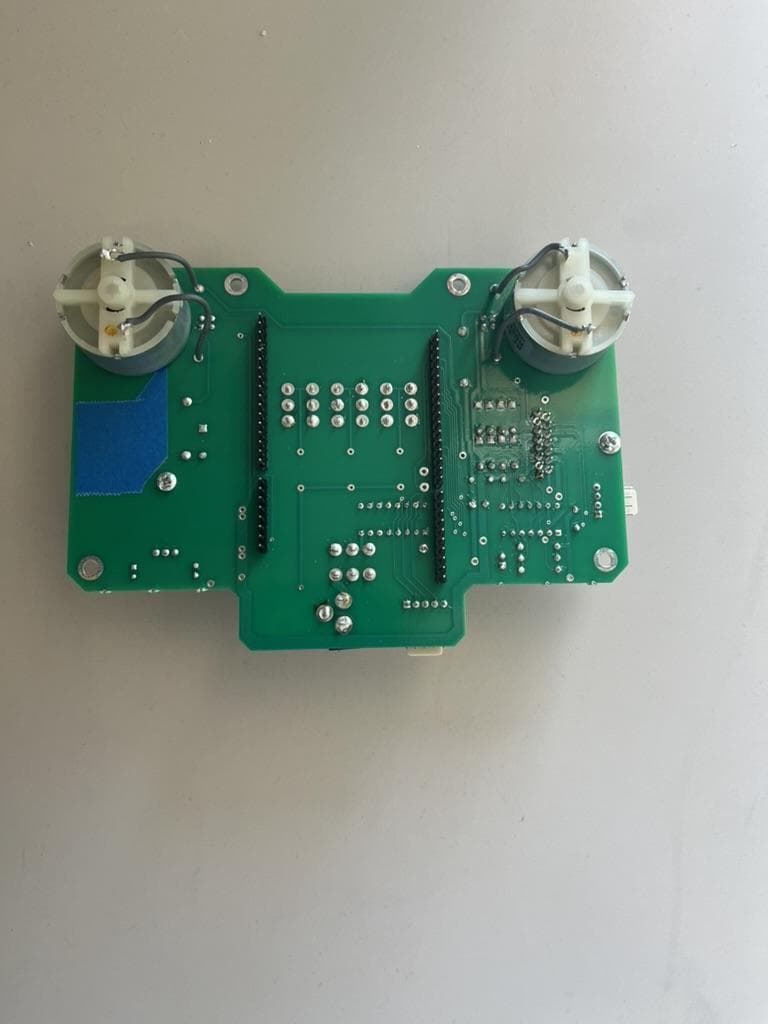 Green controller board with two motors mounted on it.