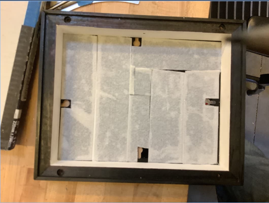 The finished frame seen from the back: dark stained outside, white painted inside edge, diffusing paper across it.